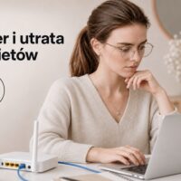 Kobieta przy laptopie diagnozująca domową sieć z routerem i przewodem Ethernet.